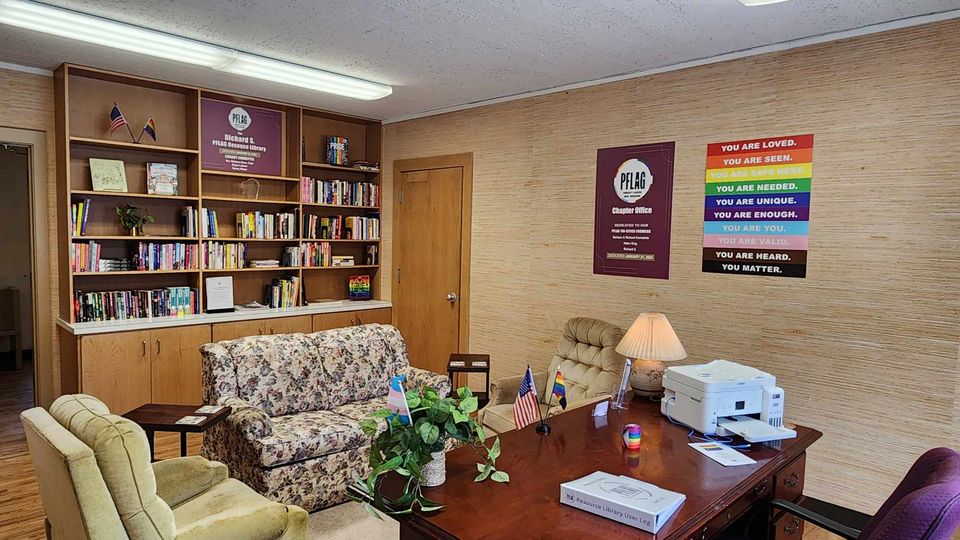 Chapter office and resource library with bookshelves, a sofa and a rainbow poster