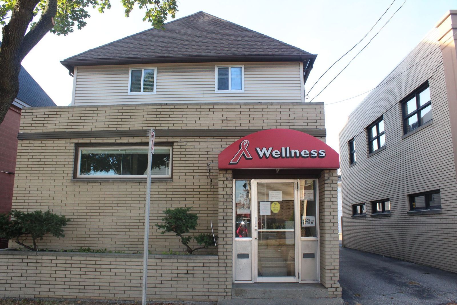 Wellness AIDS Services office in Flint with a red awning and red ribbon logo