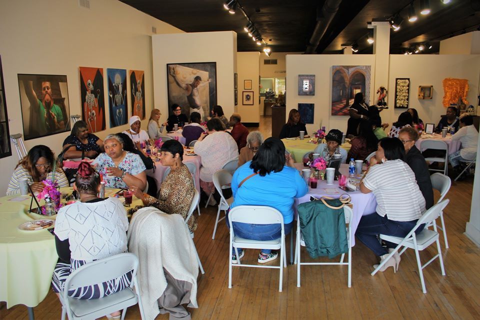 Mother's Day brunch: women chat at decorated tables in an art gallery