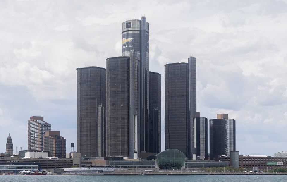 A Renaissance Center Windsorból, a Detroit folyó túlpartjáról, 2025 májusában: középen a 73 emeletes hotelhenger, körülötte a 39 emeletes irodatornyok, a vízparton az üvegboltozatos Wintergarden