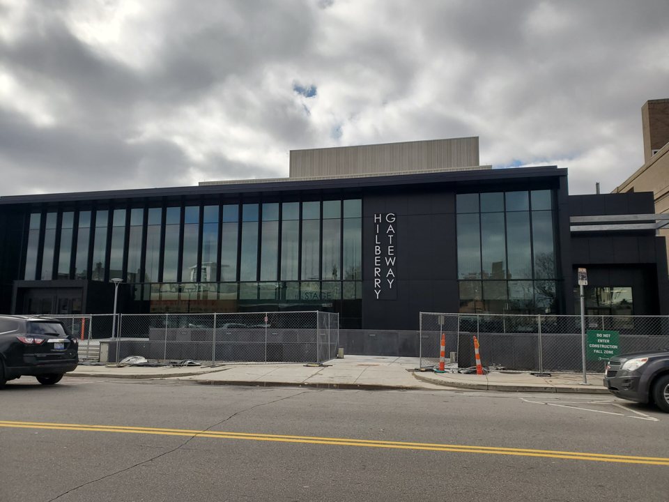 The black, glass-walled Hilberry Gateway building with its vertical HILBERRY GATEWAY lettering, still fenced off for construction