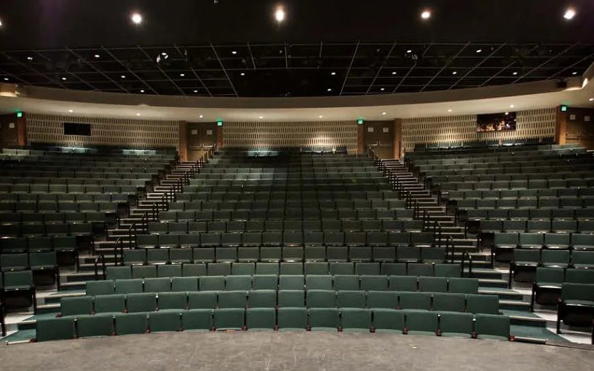 Meadow Brook Theatre's empty auditorium with green seats, seen from the edge of the stage