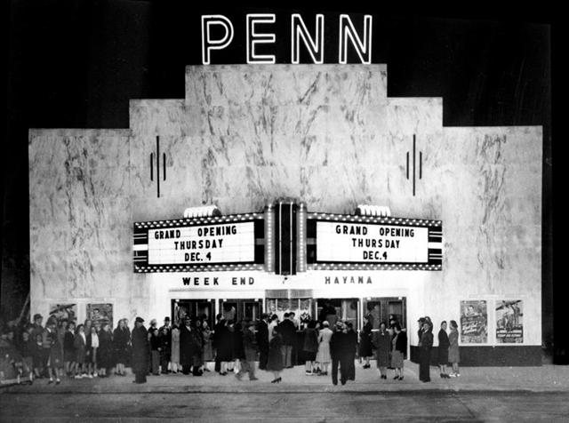 Black-and-white archive photo of a crowd outside the Penn Theatre, the marquee announcing the grand opening on Thursday, December 4