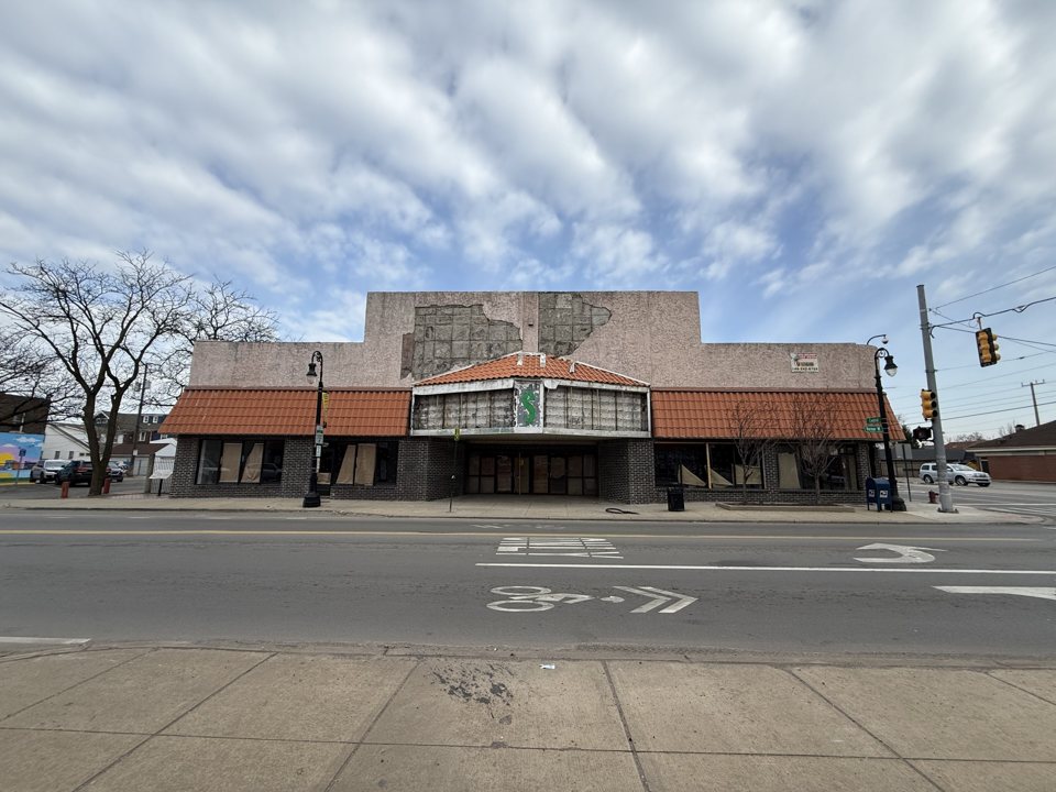The former Rio Theater's worn pink facade and tiled canopy on West Vernor, mid-renovation in April 2025
