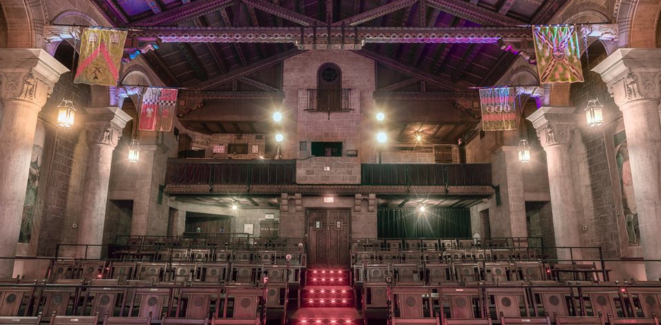 The auditorium seen from the stage, with stone columns, banners and the balcony