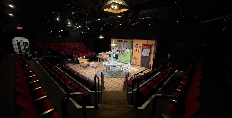 The intimate theatre's red seats surround a kitchen set on three sides