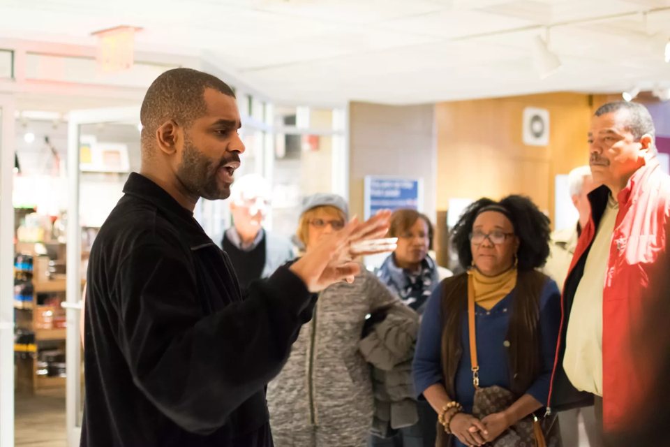 A guide talks to a small group in an exhibit hall