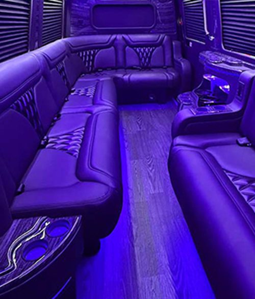 Purple-lit long bench seats and a wood-look floor inside the vehicle