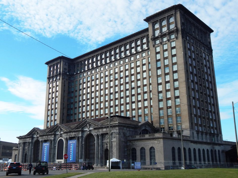 The renovated Michigan Central Station's tall stone building against a blue sky