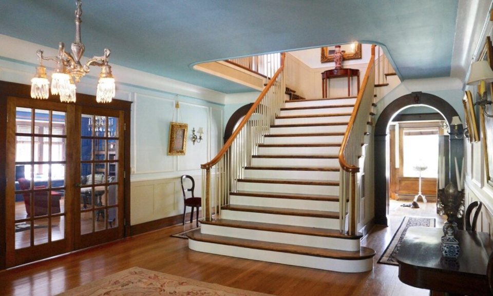 An ornate staircase leads upward inside a Palmer Woods mansion