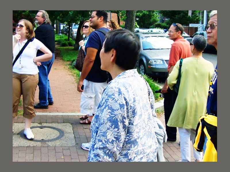 A tour group walks along a Detroit street with their guide